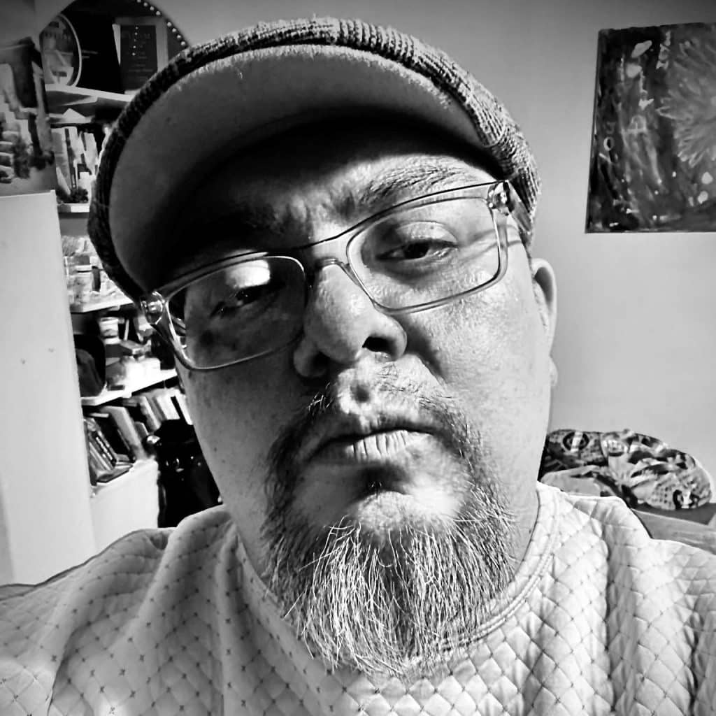 A black and white picture of a man with a small hat on.