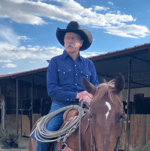 A man in a cowboy hat riding a horse.