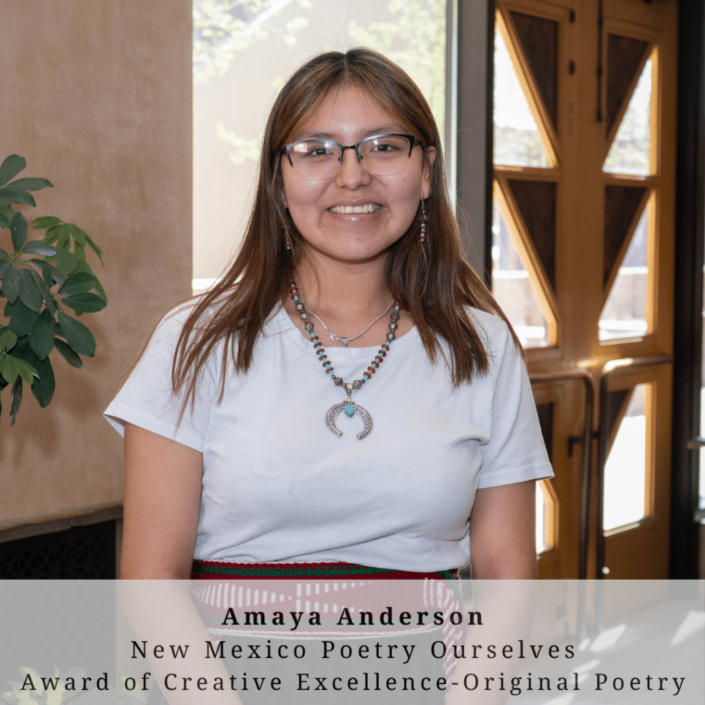 A young woman with long brown hair wearing glasses