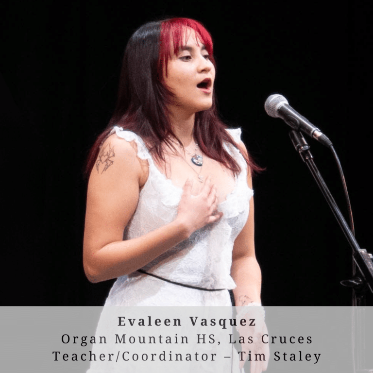 A young woman with red and black hair on stage