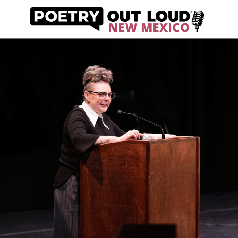 A woman with light hair and glasses on stage