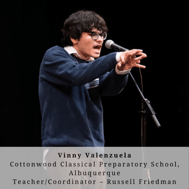 A young man with dark hair and glasses on stage