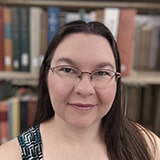 A woman with long brown hair and glasses